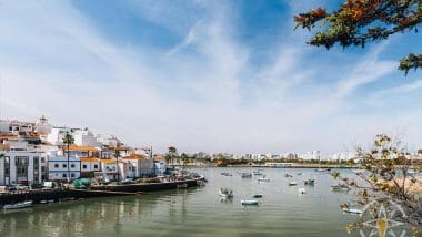 boats in a body of water with buildings in the background, ferragudo