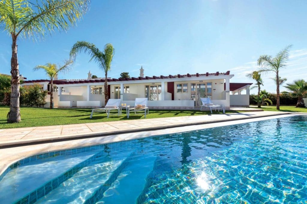 a pool with a house and palm trees, Holiday Ferragudo